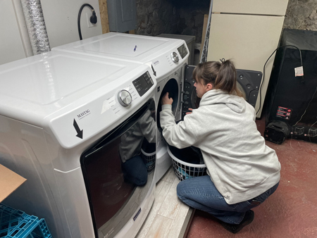 Carrie Boling, another resident at All Things Are Possible recovery house in Peru, does her laundry in the house’s basement. Staff photo by Jared Keever