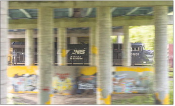 A Norfolk Southern freight train passes under Goshen’s North Third Street overpass, which is an area tagged by several gangs Friday. Staff photo by Joseph Weiser