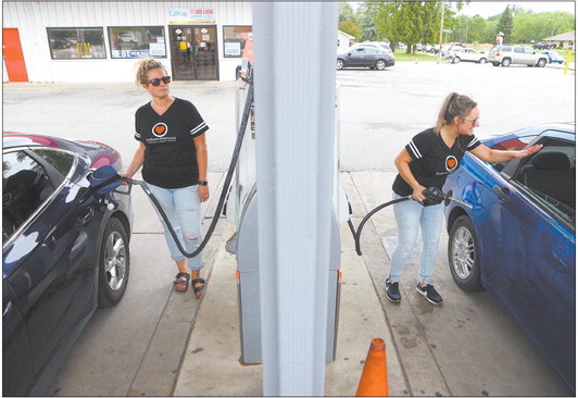 Allison Cox, left, and Shelley Preston pump gas for customers during Indiana Heartland Federal Credit Union’s free gas giveaway at Woody’s Food Store on Wednesday. Staff photo by Kelly Lafferty Gerber