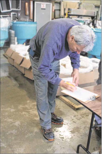 Property manager Jeff Malwitz, who supervises the four-man crew at Cikana State Fish Hatchery in Martinsville, records each load of fry transferred to boxes. Staff photo by Lew Freedman
