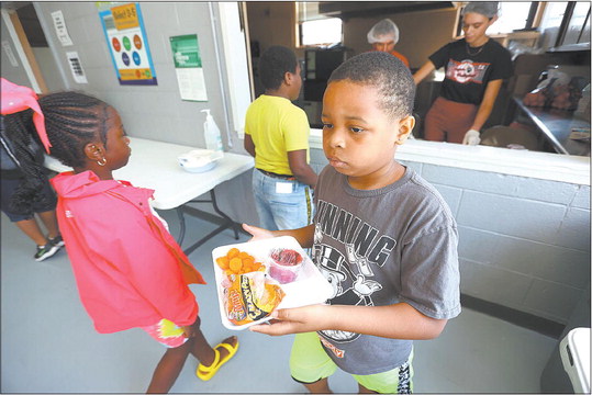 Noah Hicks walks away with his free lunch June 22 at the Carver Community Center in Kokomo. The Keep Kids Fed Act, passed June 25, allows for grab-and-go summer lunches and ups the reimbursement rate for meals served during the school year. However, it does not extend universal free school meals for all students. The end of this waiver has advocates concerned for student hunger. Tim Bath | Kokomo Tribune
