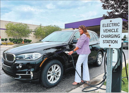 Lisa Putnam hooks her 2017 BMW X5 up to a Tesla charging station at Harrah’s Hoosier Park Racing & Casino. “I charge my car every day,” said Putnam, a VIP host at the racino. “If I’m able to charge here at work, I can go almost three months on a tank of gas.” Andy Knight | The Herald Bulletin
