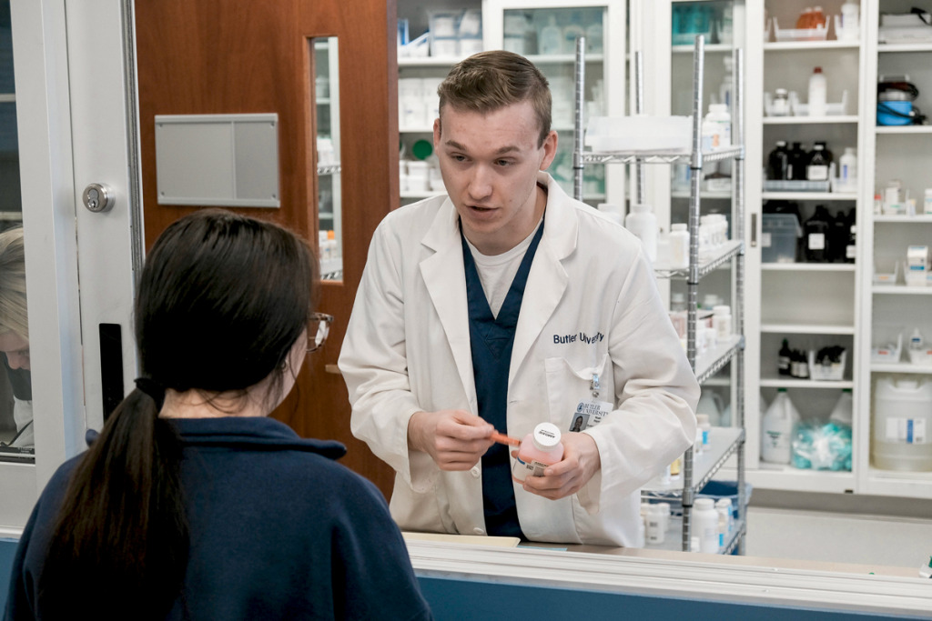 Pharmacy student Noah Heyne works in the mock pharmacy at Butler University where prospective pharmacy students learn to deal with a crush of demands. (IBJ photo/Eric Learned)