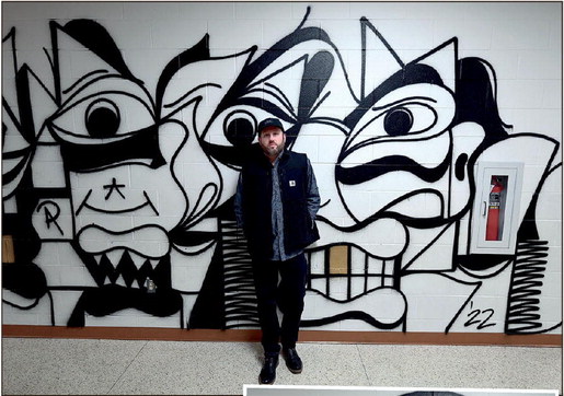 Artist Steven Raez hopes that his work will inspire the many students that walk by it throughout the school week at Benjamin Franklin Elementary School. Above, Raez poses for a photo near the mural on Tuesday. He describes his mural, closeup seen on right, as “futuristic” and “Picasso-inspired.” Staff photo by Joseph C. Garza