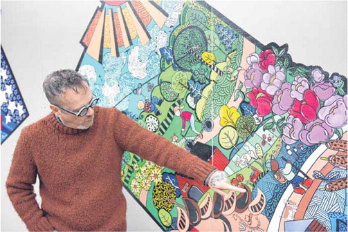 Artist Mark Schmidt stands in front of and points out details in his mural behind the Brown County Visitors Center on Nov. 28. The mural was funded by a grant from Indiana Destination Development Corporation. The mural shows different aspects highlighting life in Brown County. Staff photo by Corbin Parmer