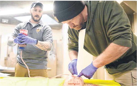 Greenfield Police departments Brandon Pope, left, instructs fellow officer Zach Petrie while demonstrating with a model on how to pack a wound with gauze. Staff photo by Tom Russo