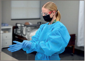Western Boone High School student Jacelyn Wison is timed as she dons personal protective equipment during the mock regional competition for HOSA: Future Health Professionals on Friday at Ivy Tech Community College Terre Haute. Staff photo by Joseph C. Garza