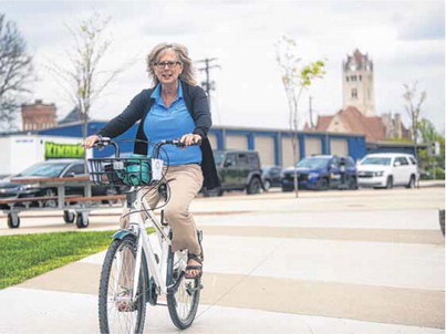 Greenfield Parks director Ellen Kuker takes a ride around Depot Street Park on one of the bikes offered through a new bike share program created by a Leadership Hancock County team. Staff photo by Tom Russo