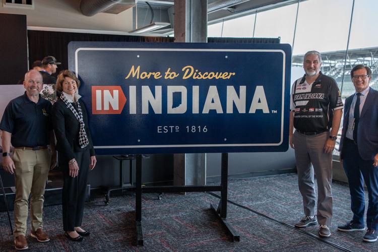 Officials stand Thursday near the new sign that will welcome visitors to Indiana. From left, INDOT Commissioner Mike Smith, IDDC CEO Elaine Bedel, Gov. Eric Holcomb and Doug Boles, president of the Indianapolis Motor Speedway. Provided image
