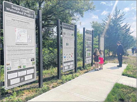 Hancock County Councilman Scott Woolridge and his twin daughters, Elizabeth and Rachel, check out the information panels at the new Eagle Station trailhead along the Pennsy Trail, just west of S. County Road 400 West. Shelley Swift | Daily Reporter