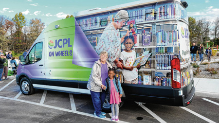 Jane Bingham, left, and her granddaughter Charlotte pose in front of the JCPL on Wheels bookmobile, which features a photograph of them on side during an event Nov. 4 at Kephart Park in Bargersville. SUBMITTED PHOTO