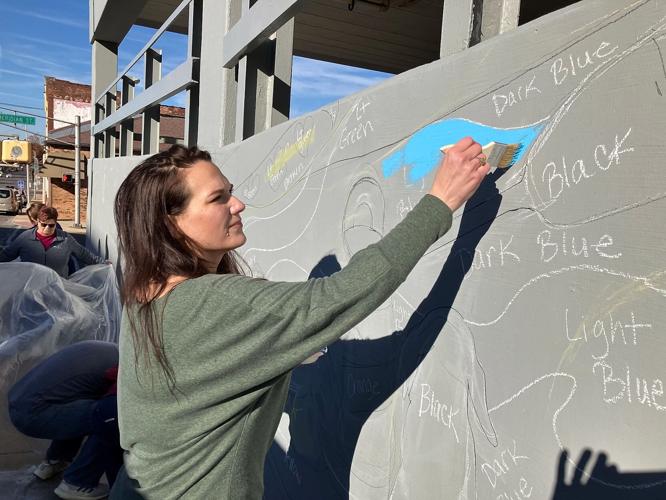 Rachell McCracken of the Anderson Leadership Academy class applies blue paint to the county bicentennial mural on Eighth Street.  Staff photo by Ken de la Bastide | The Herald Bulletin