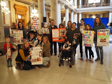 Families rally for a second week at the Indiana Statehouse to protest a protest cut to Medicaid services that pay for parents to be attendants for their severely disabled children. (Whitney Downard/Indiana Capital Chronicle)