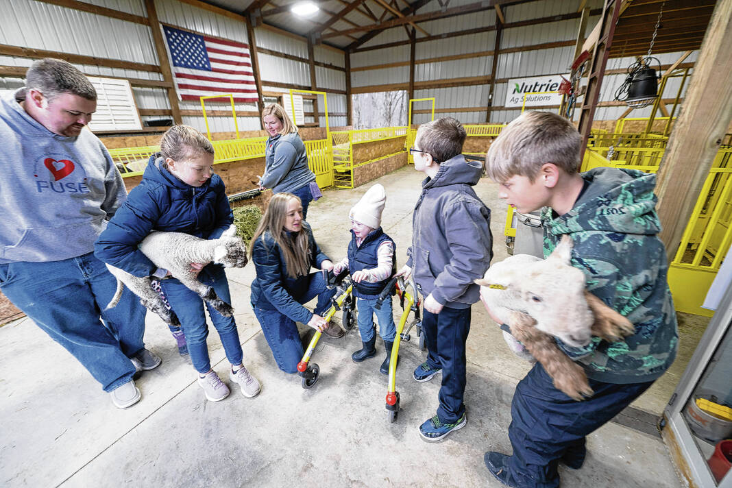  Emily Meckel along with daughter Emery (center) gather with others at the Meckel farm in Hancock County enjoying the different livestock animals. The Meckels started Hancock Poss-Abilities in 2023, which is expected to grow in 2024. Daily Reporter file photo