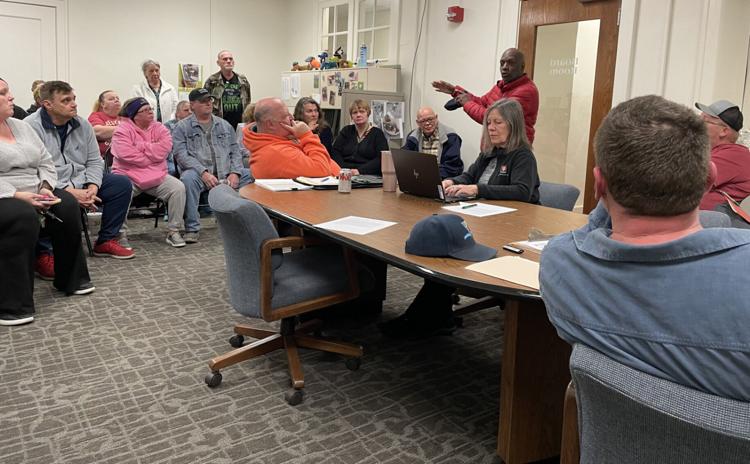 Community member Jeff Coatie (standing, in red) shares his personal experiences with homelessness and working with people who are currently living unhoused. Travis Weik / C-T photo