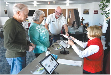Poll workers Carole Greenwalt and Ron Stoughton check in voters James and Christi Renforth at the Cross Roads United Methodist Church vote center in Anderson in this November 2023 photo. Richard Sitler, file | CNHI News Indiana