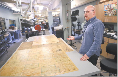 Seth Irwin, conservator for the Indiana State Library division of rare books and manuscripts, talks about an old map he’s been preserving in the conservation lab on Tuesday. 
Photo by Kelly Lafferty Gerber | CNHI News Indiana