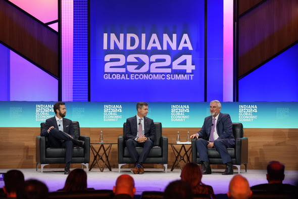 Gov. Eric Holcomb, right, speaks with Eli Lilly and Company Chair and CEO David A. Ricks, middle, Friday at an economic summit event. Lilly announced an additional $5.3 billion investment in the Lebanon LEAP district. (Indiana Capital Chronicle/Photo courtesy governor’s office)