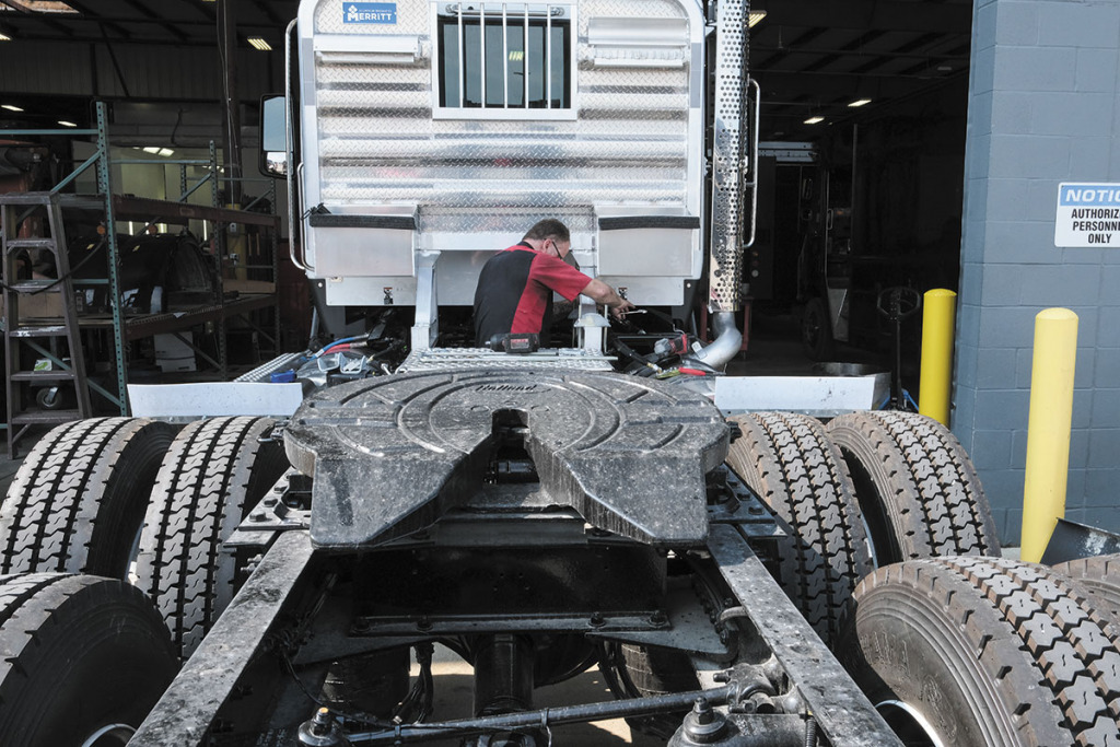 Body shop technician Mark Cox works on a semitruck at Palmer Trucks. Palmer hasn’t seen a recent drop in business despite the industry’s downturn. (IBJ photo/Eric Learned)