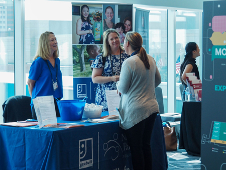 Representatives for the Goodwill Nurse-Family Partnership speak with a summit attendee on July 23, 2024, during the Labor of Love Summit at the JW Marriott Indianapolis. (Mia Hilkowitz/Indiana Capital Chronicle)