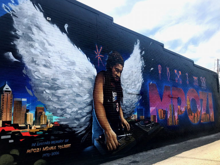 An updated version of the 2008 mural paying tribute to late Indianapolis photographer and DJ Mpozi Mshale Tolbert was painted in 2020 on the northern exterior of 6308 Guilford Ave. (IBJ photo/Dave Lindquist)