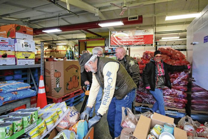 Capt. TA Smith, back center, was one of the deputies delivering the food that the Bartholomew County Sheriff Department collected during its annual Pack a Patrol Car food drive to Love Chapel, Columbus,, Thursday, November 21, 2024. Carla Clark | For The Republic 