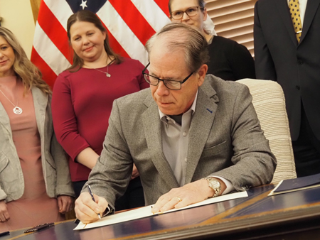 Gov. Mike Braun signs executive orders in the Governor’s Office, in front of advocates involved in the orders’ development, on Wednesday, Jan. 22, 2025. (Leslie Bonilla Muñiz/Indiana Capital Chronicle)