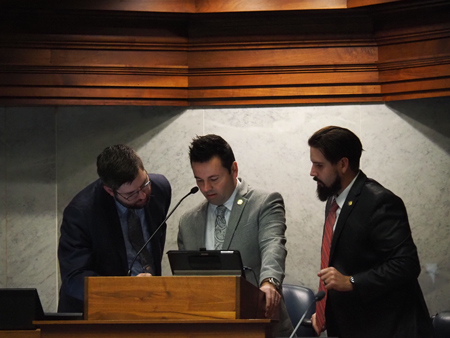  Lt. Gov. Micah Beckwith, middle, consults a screen during a point of order aimed at him, on Thursday Feb. 6, 2025. Democrats condemned him for posting on his X account during the debate he was presiding over. (Leslie Bonilla Muñiz/Indiana Capital Chronicle)