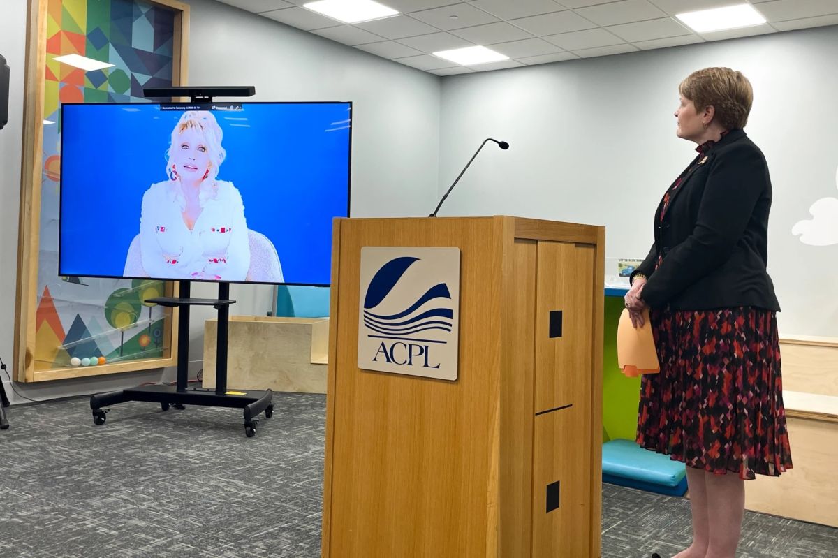 Allen County Public Library executive director Susan Baier stands by as a video from Dolly Parton explaining the mission of the Imagination Library plays. (Ella Abbott / WBOI News)