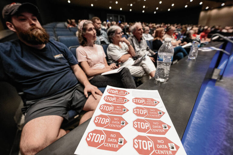 Stickers bear a message of protest at a public information session Thursday at Greenfield-Central High School. Tom Russo | Daily Reporter