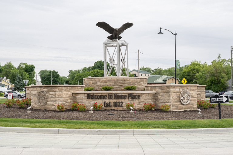 The East 106th Street and College Avenue roundabout includes a sculpture designed by Home Place residents. Red-tailed hawks are common neighborhood sights, and the railroad lantern represents a bygone interurban railroad. (IBJ photo/Chad Williams)