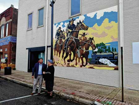 Seymour Mayor Matt Nicholson, left, talks with Jamie Harris of Tampico,the artist of Seymour's newest mural 'Reno' during a ribbon-cutting for it Monday at 105 W. Second in the city's downtown. Submitted image