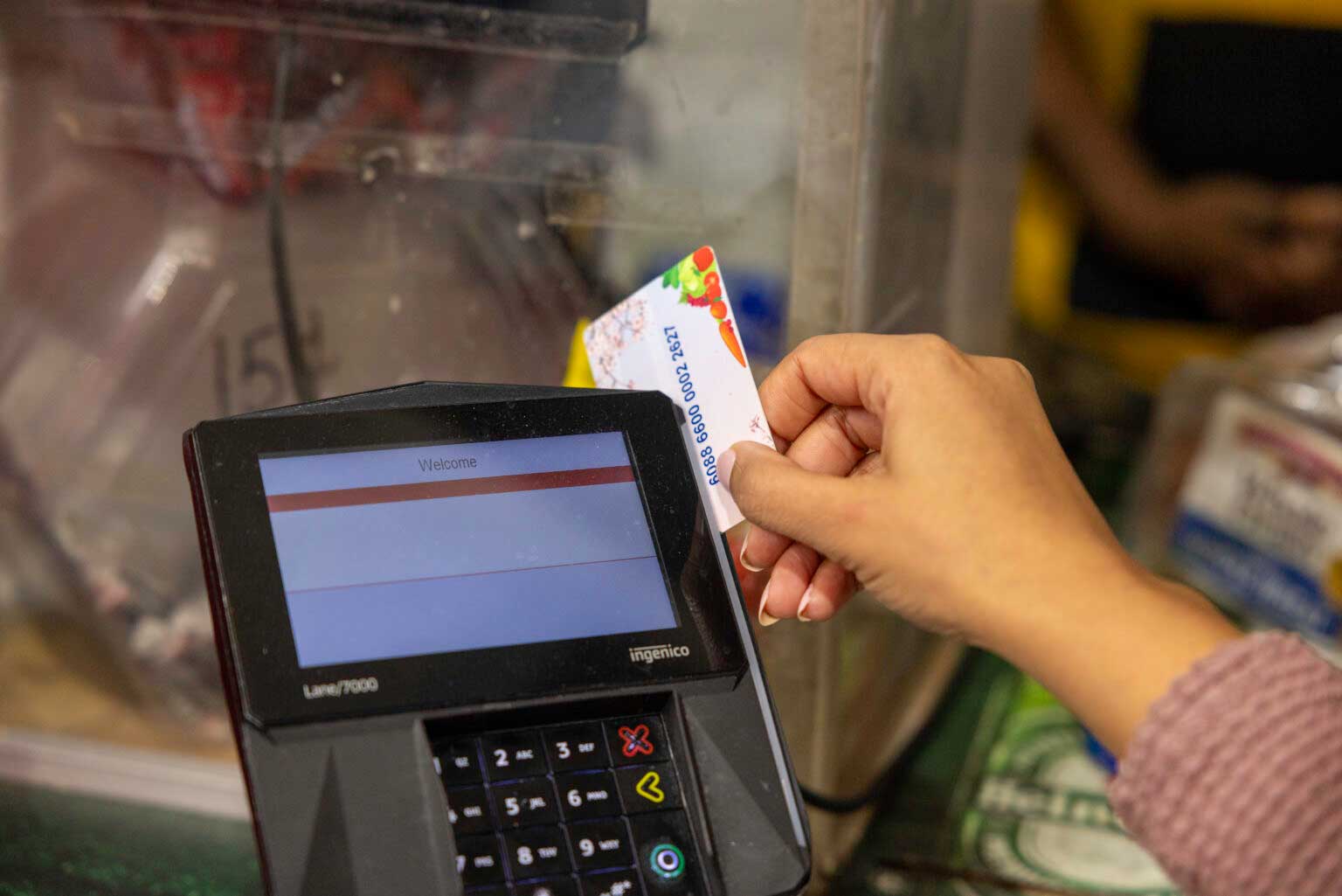  A shopper who receives SNAP benefits slides an EBT card at a checkout counter in a Washington, D.C., grocery store in December 2024. (Photo by U.S. Department of Agriculture)