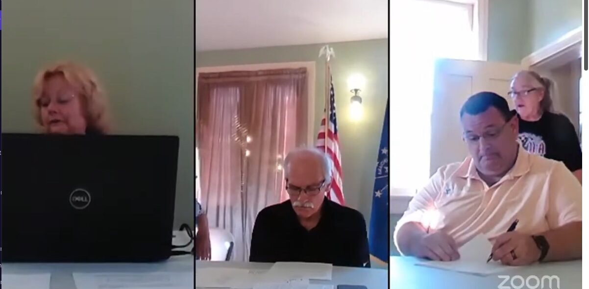 A resident, back, surprises the Lewisville Town Board members during a July meeting that was streamed online. (Screenshot from livestream)