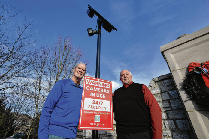 Rob Richards, a board member of the Wyncrest Homeowners Association, left, and Brian Benham, president of the Shadowood HOA, pose for a photograph next to a recently installed Flock Safety license plate reader at the entrance to Wyncrest on Wednesday in Bargersville. Cameras have been installed at both neighborhoods, a byproduct of a collaboration between northwestern Johnson County HOAs who’ve formed a coalition to advocate for their neighborhoods collectively. 
Noah Crenshaw | Daily Journal