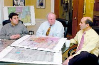 From left, Marc Stein, project development, John Phair, president, and Frank Perri, senior vice president of development, gather around color maps and plans for Portage Prairie at their offices in downtown South Bend. 
Tribune Photo/SHAYNA BRESLIN