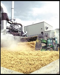 A tractor scoops up wet-cake, a corn meal byproduct of the ethanol process that is sold to farmers for cattle feed, at the Adkins Ethanol Plant near Lena, Ill.