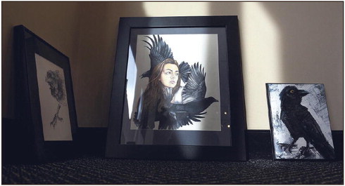 In the light: Kelly Ferguson’s “The Witching Hour” sits in Wednesday’s sunlight with other pieces ready to be hung in the Arts Illiana gallery for the “Crow Show.” Tribune-Star/Joseph C. Garza