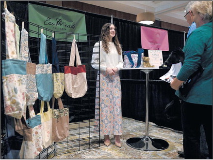 Makayla Mackey, a Terre Haute South Vigo senior, talks about her re-useable grocery totes made out of recycled material during the Vigo and Sullivan County CEO programs’ trade show Thursday at the Terre Haute Convention Center. Tribune-Star/Joseph C. Garza